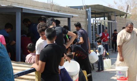 In the "African way"... Basra people stand in queues in the morning to get drinking water